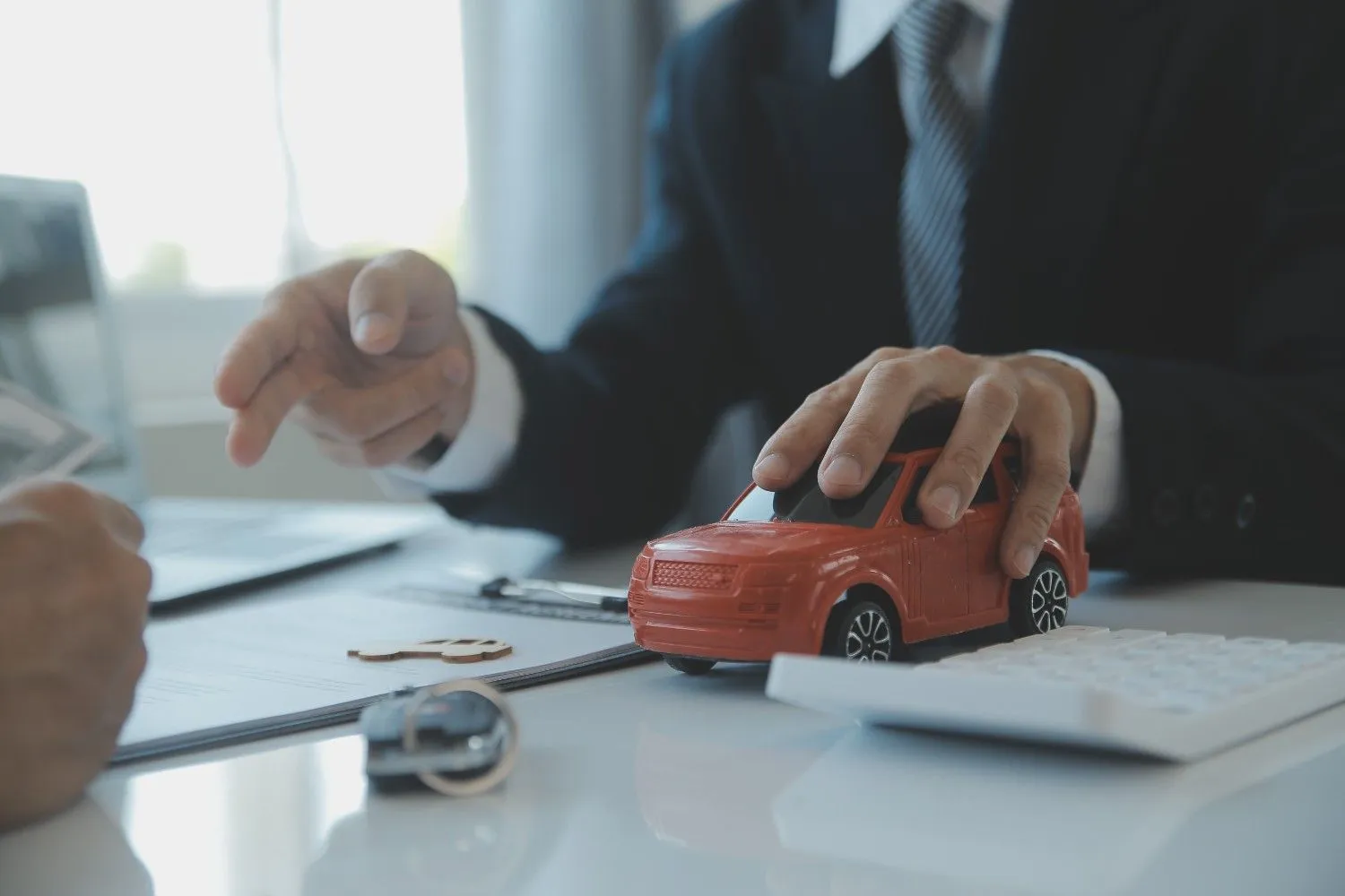 Toy car, keys and a policy document on a desk