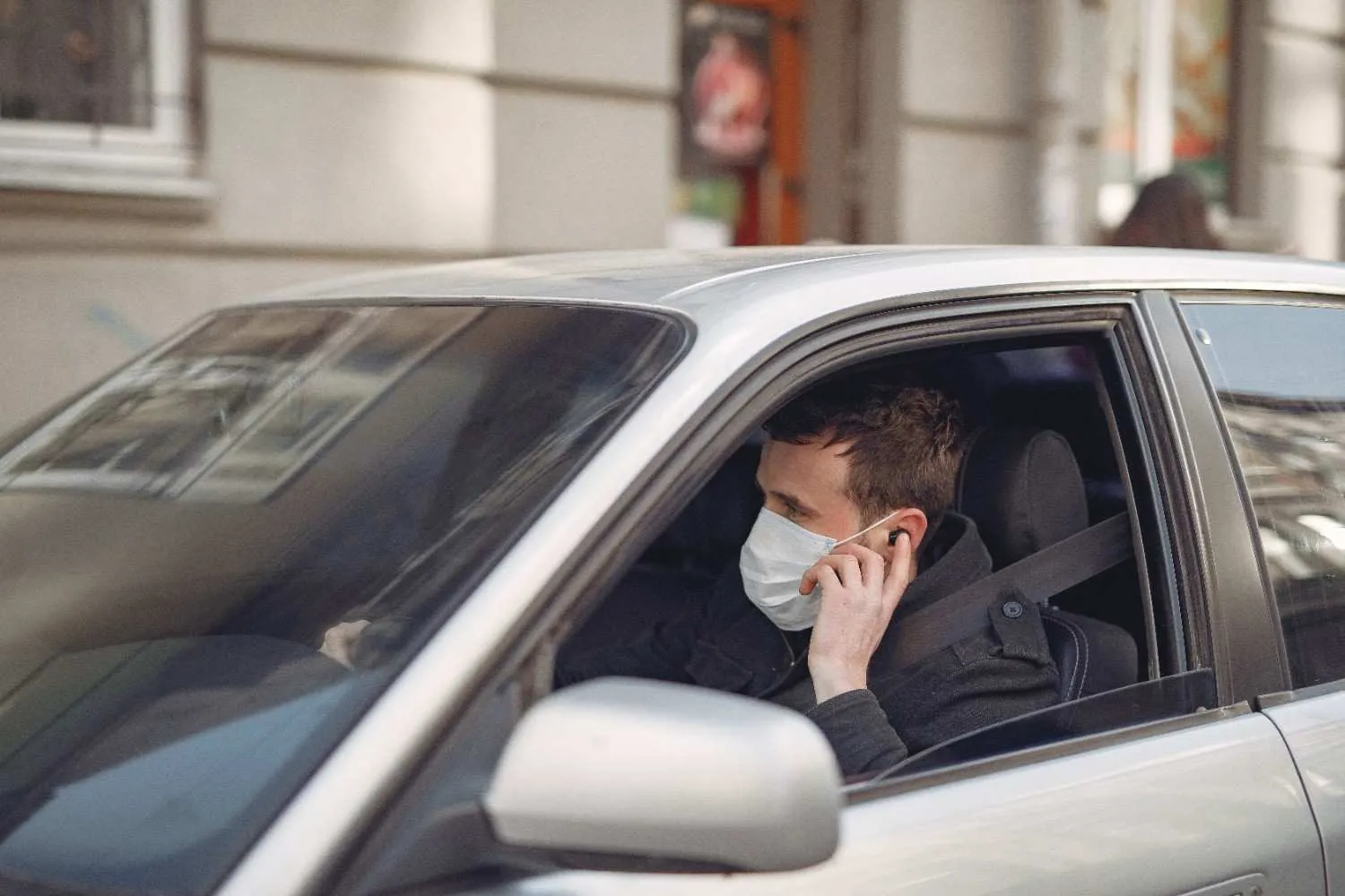Driver seated behind the wheel of a car on a city street